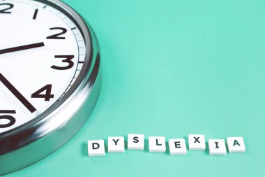 Büyük bir analog disleksi ve okuma kelimelerle okuma zorluk ve bozukluğu kavramı nane arka plan üzerinde saat. Eğitim ve Nöroloji