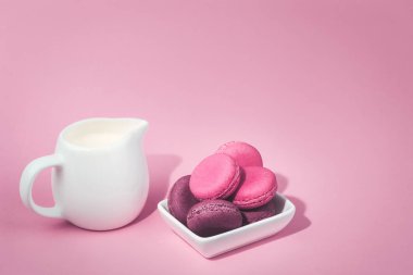 Birkaç lezzetli pembe macaroons kase ve süt kavanoz