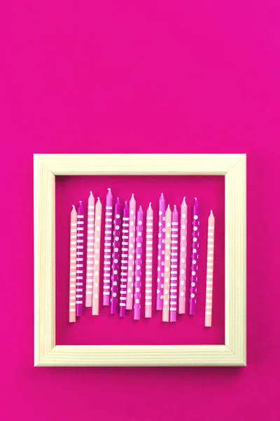 Růžová a fucsia svíčky v rámečku na růžové — Stock fotografie