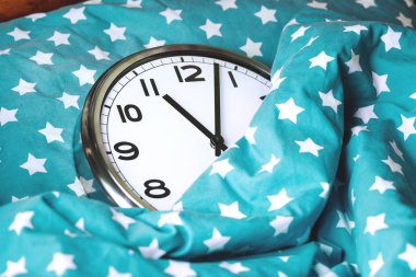 Mavi bir yatakta büyük duvar saati