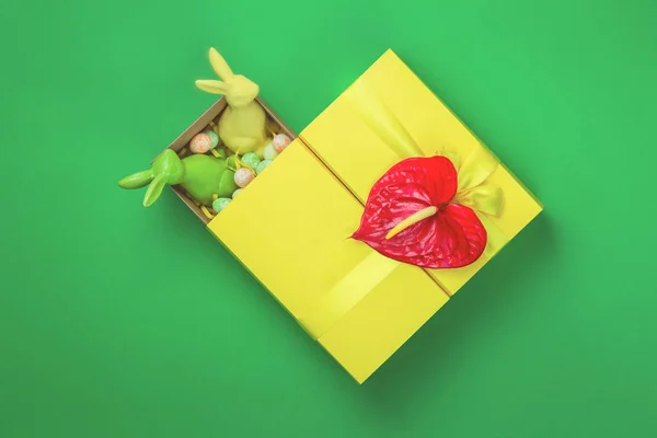 Caja de regalo de Pascua amarilla con dos conejitos sobre fondo verde — Foto de Stock