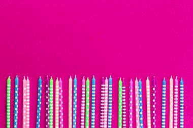 Neon Pembe arka planda renkli mumlar satır
