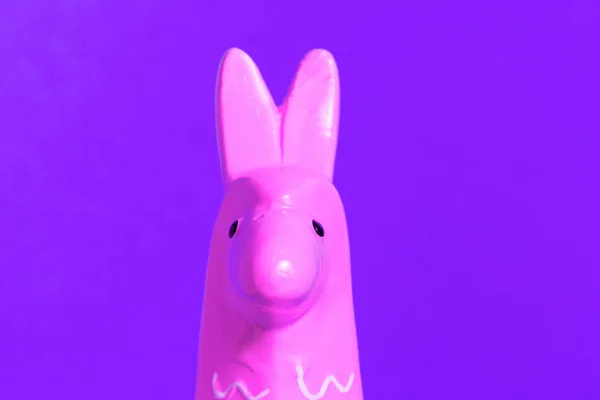 Pink toy lama head on purple background — Stock Photo, Image