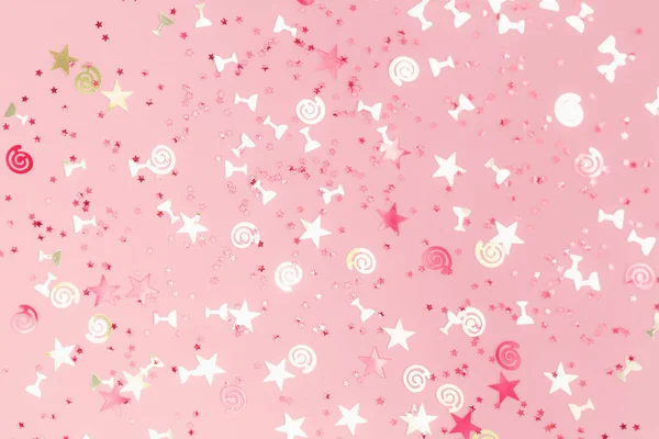 Golden sparkling assorted festive confetti on pink — Stock Photo, Image