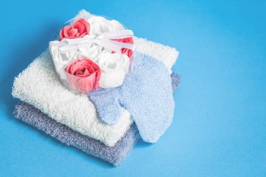 Çiçek banyo sabun bombaları ve mavi arka plan üzerinde iki havlu