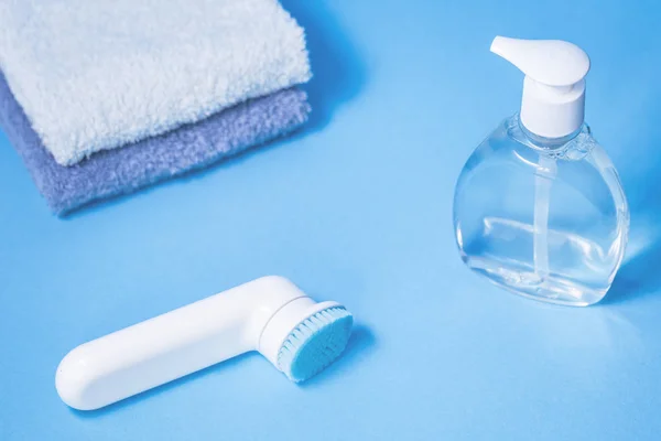 Vloeibare transparante zeep en twee handdoeken op blauwe achtergrond — Stockfoto