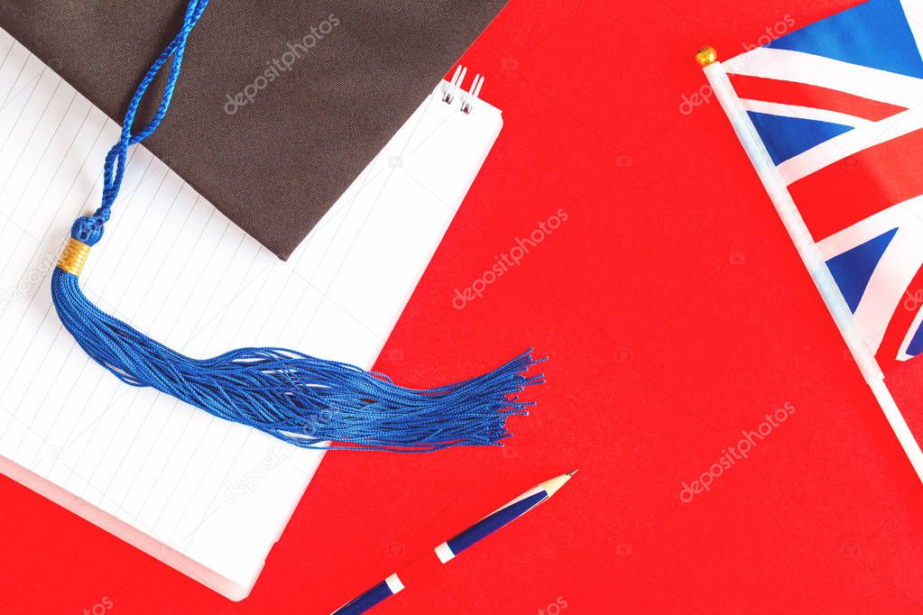 Black graduation cap with british union jack flag on red
