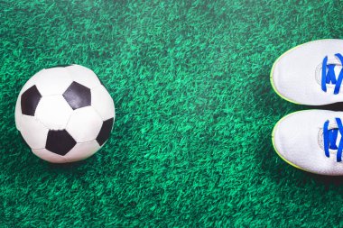 Futbol topu ve ayakkabısı yeşil suni çim karşı