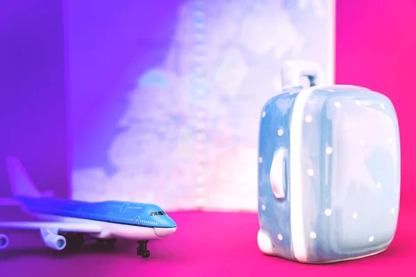 ピンクの紫色の航空機とスーツケースの旅行コンセプト — ストック写真