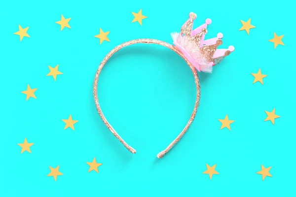Pink and gold princess crown headband on blue background