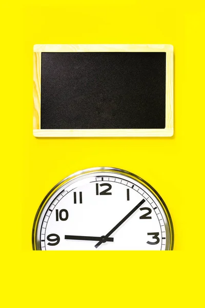 Partie de l'horloge murale et tableau d'affichage noir sur fond jaune — Photo