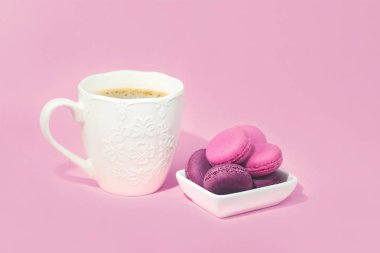 Birkaç lezzetli pembe macarons kase ve kahve
