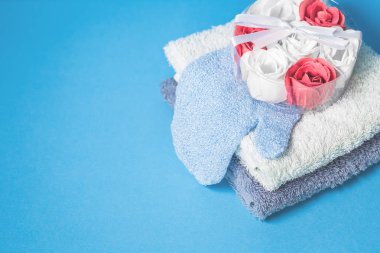 Çiçek banyo sabun bombaları ve mavi arka plan üzerinde iki havlu