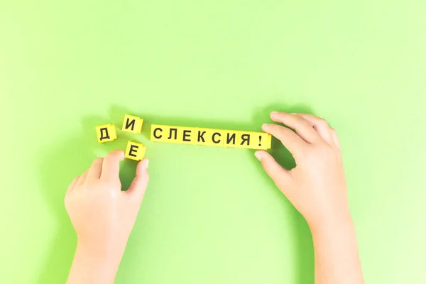 Hands with Dyslexia word in Russian on green — Stock Photo, Image