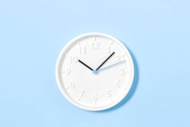 pastel mavi arka plan üzerinde beyaz duvar saati