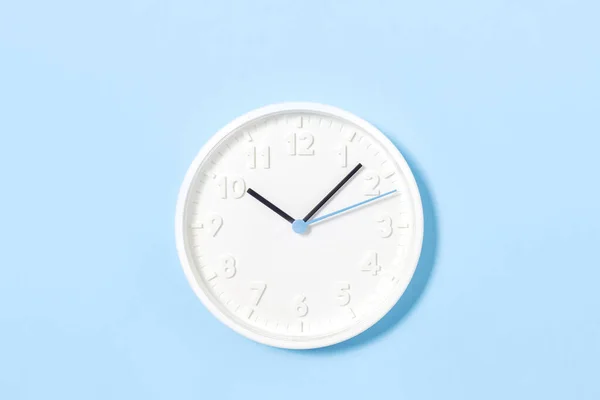 Λευκό ρολόι τοίχου σε παστέλ μπλε φόντο — Φωτογραφία Αρχείου