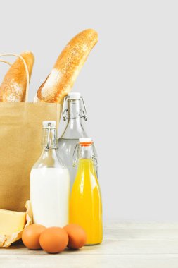 Süt ürünleri ile birlikte sahte kağıt poşet içinde iki Fransız ekmeği, grinin üzerine de peynirli süt şişesi. Pastane teslimat servisi kopyalama alanı. Market ya da üretim pazarı