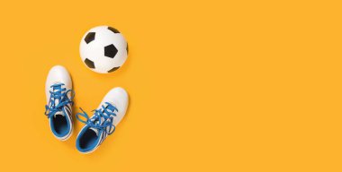 Beyaz kramponlu futbol topu, modaya uygun sarı turuncu arka plan, fotokopi alanı, futbol ya da spor sınıfı ve okul konseptindeki turnuva ile üst manzara. Uzun pankart