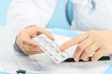 Kapatın. Kafkasyalı kadın doktor hapları ya da reçeteli ilaçları işaret ediyor. İlaç ve eczane. Pratisyen hekim ya da aile doktoru randevusu. Tıbbi konsept. Eczane. Yüzü yok.