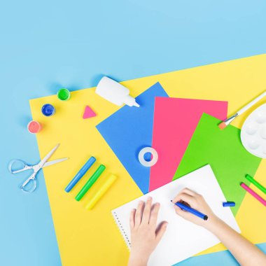 Renkli kağıt, boya ve okul kağıtları ve el çizimleri.