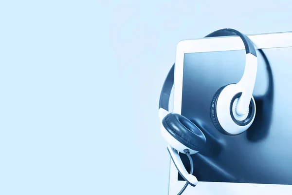 Kapatın. Boş ekranlı, kulaklıklı, beyaz masa mavisi arka plan ve kopyalama alanı olan bir laptop. Uzaktan öğrenme ya da evden çalışma, çevrimiçi kurslar, alışveriş asgari konsept. Yardım masası çağrı merkezi