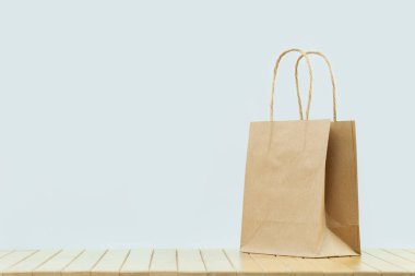 Parlak, düz bir kağıt, gri bir çanta taşıyor. Mal ve bakkal teslimatı, alışveriş kuryesi. Çevre ve çevre dostu ambalaj, plastik ücretsiz servis. Alışveriş ve satış. Boşluk afişini kopyala