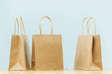 Birkaç parlak kağıt, gri renkte çanta taşır. Mal ve bakkal teslimatı, alışveriş kuryesi. Çevre ve çevre dostu ambalaj, plastik ücretsiz servis. Alışveriş ve satış. Boşluğu kopyala