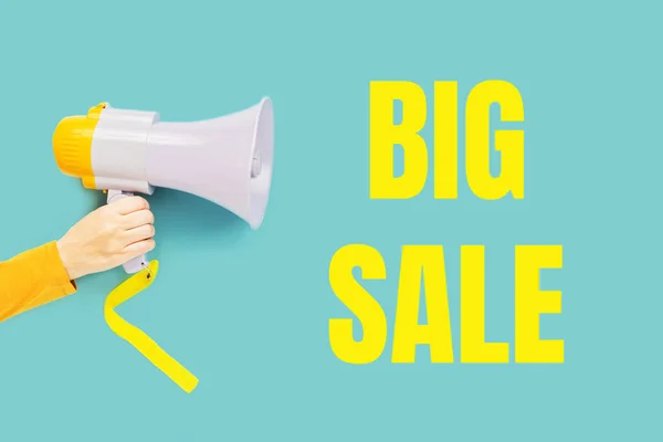 Big sale text in yellow on teal and a hand with megaphone. Sale commercial, best price guarantee. Clearance announcement. Shopping concept