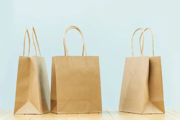 Several buff plain paper carry bags on grey. Delivery service of goods and grocery, shopping courier. Environment and eco friendly packaging, plastic free takeaway. Shopping and sale. Copy space