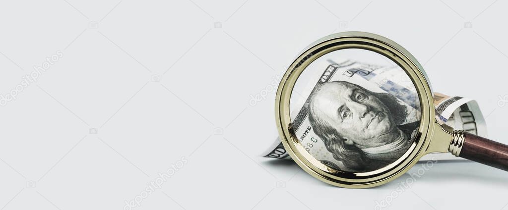 One hundred dollars note under magnifying glass on grey background banner. Finance markets. investments loans earnings concept. Personal accounting debts and credits bankruptcy with copy space