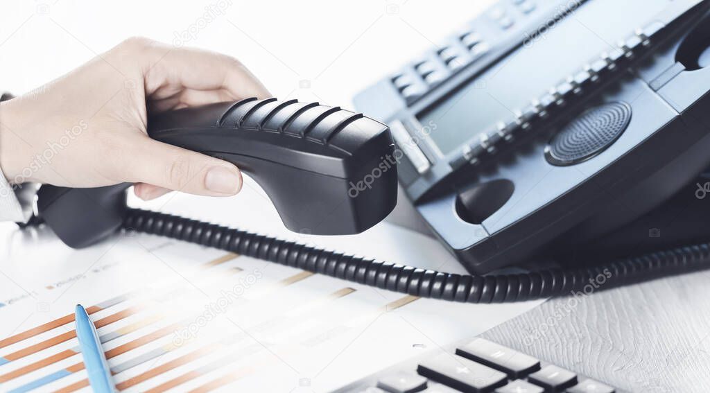 business communications. Finance graphs. Using voip phone. office, close up of hand with receiver. Conference call, contact us or hotline banner. IP telephony, Telemarketing. Help desk call centre