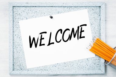 Ofis masasının üstündeki ilan panosuna hoş geldin mesajı. İş finans toplantısı veya atölye sunumu ve eğitim konsepti. Hesap makinesi ve klasörler. Gemiye hoş geldiniz ya da göreve kabul edildiniz. Boşluğu kopyala