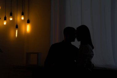 Karanlıkta elinde lambayla âşıkların siluetleri