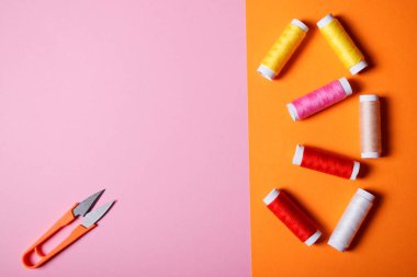 Dikiş ve özel makas parlak çift renkli pembe ve turuncu zemin üzerine boşaltmak için renkli konu kümesi.