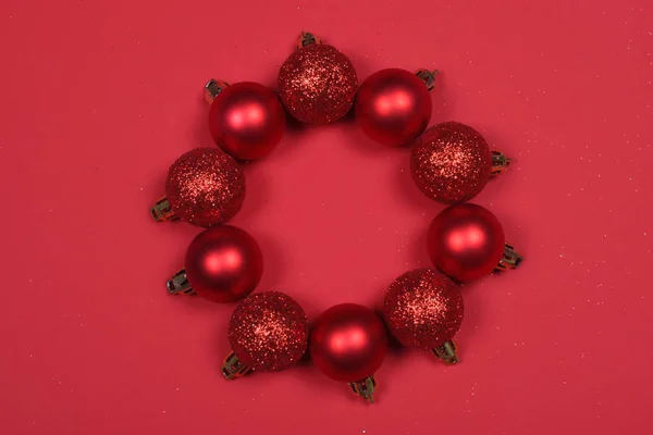 Red Baubles formando uma grinalda de Natal no fundo vermelho . — Fotografia de Stock