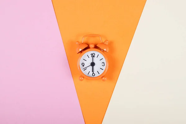 Renkli arka plan üzerinde turuncu çalar saat. — Stok fotoğraf