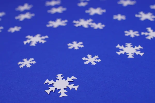 Bianco fiocco di neve coriandoli su sfondo blu . — Foto Stock