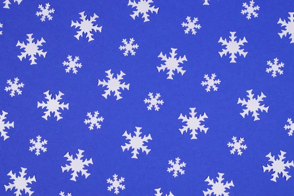 Bianco fiocco di neve coriandoli su sfondo blu . — Foto Stock