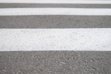 Yaya geçidi beyaz çizgiler, yakın çekim işaretleme ile asfalt yol parçası. Metin için kullanılan arka plan.