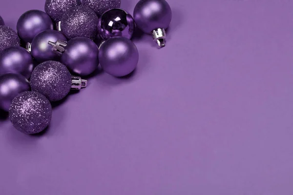 Matte and glitter purple in the corner of background of the same color with copy space. Christmas and New Year concept.