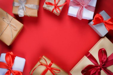 Birçok canlı kırmızı zemin üzerine ipeksi parlak kurdele ile bağlanmış kutularındaki sunar. Tatil ve kutlama kavramı için hazırlık. Kopya alanı.