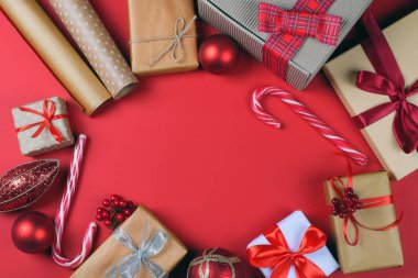Kaydırılan Noel hediyeleri ve kopya alanı kırmızı zemin üzerine şenlikli aksesuarları. Tatil için hazırlık kavramı.