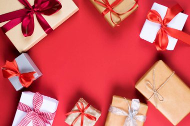 Birçok canlı kırmızı zemin üzerine ipeksi parlak kurdele ile bağlanmış kutularındaki sunar. Tatil ve kutlama kavramı için hazırlık. Kopya alanı.