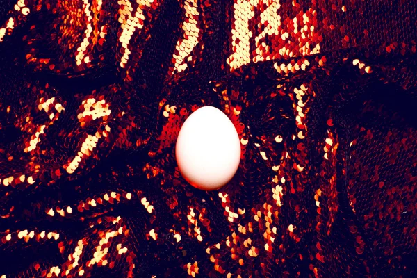 Uovo bianco su sfondo di paillettes . — Foto Stock