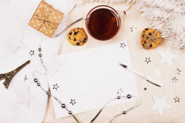 Mockup bir fincan çay ile çerezleri yontma chocolade, kart ve yazma ve küçük eiffel için kalem kumaş arka plan üzerinde kule. Kadınların yaratıcı dünya rahat.