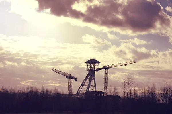 Old coal mine tower and cranes.
