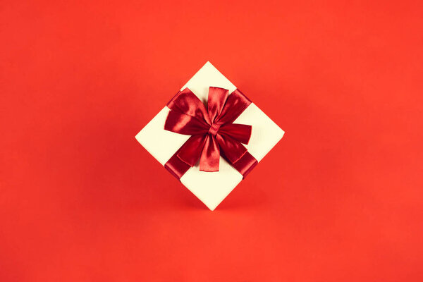 Beautiful present box on red background.