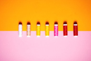 Parlak arka plan üzerinde renkli dikiş ipliği kümesi.