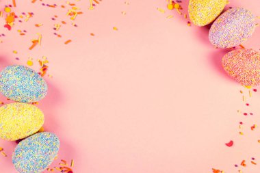 Pembe arka planda renkli paskalya yumurtaları.