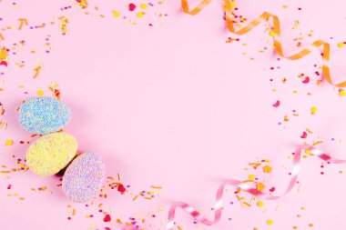 Pembe arka planda renkli paskalya yumurtaları.